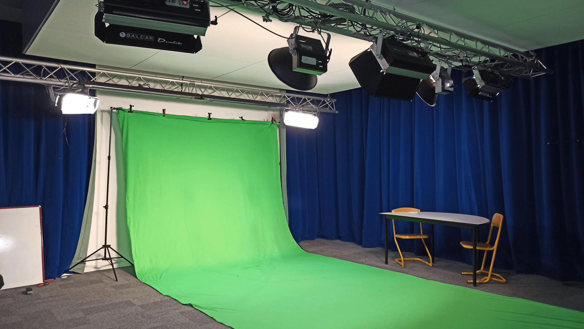 salle avec un grand fond vert faisant le mur et le sol